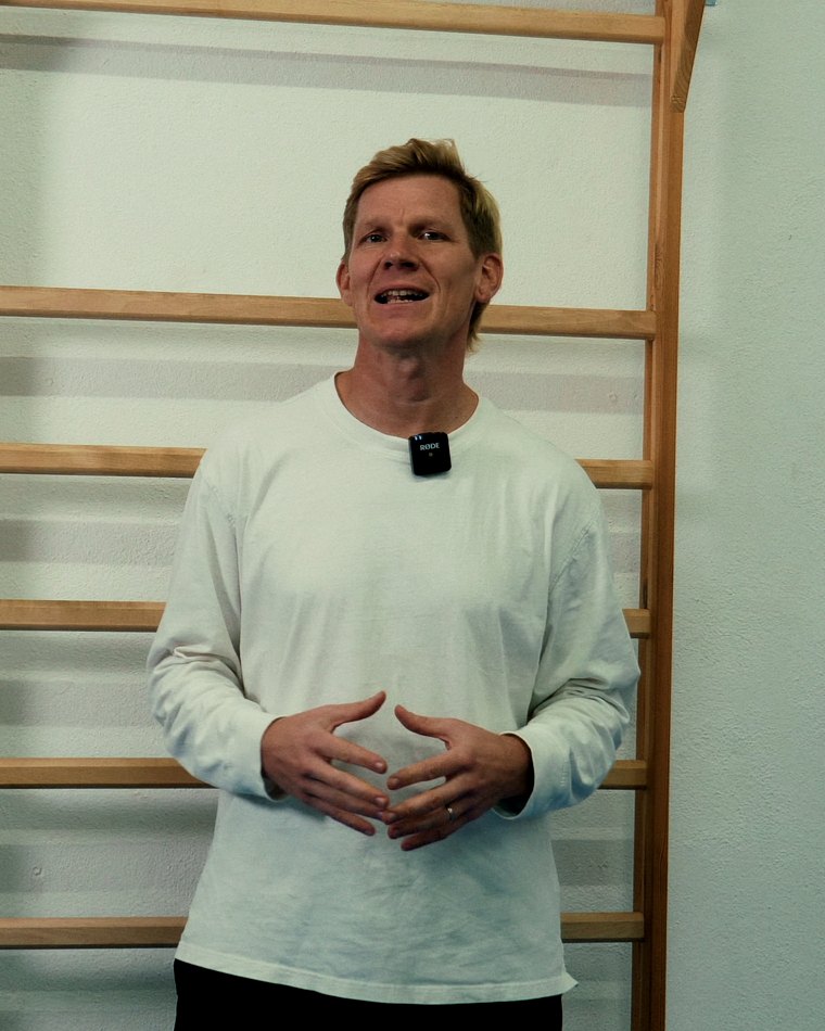 Florian Schwab, Personal Trainer aus Stuttgart, lächelt an der Sprossenwand im Studio